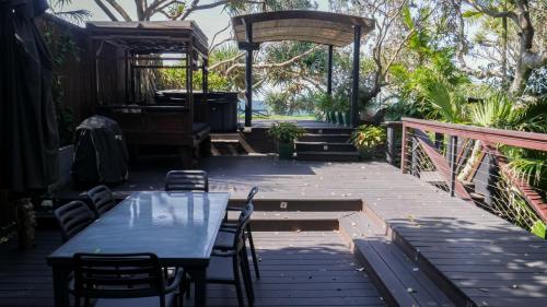 a patio with a table and chairs and a gazebo at Shambhala @ Byron in Byron Bay