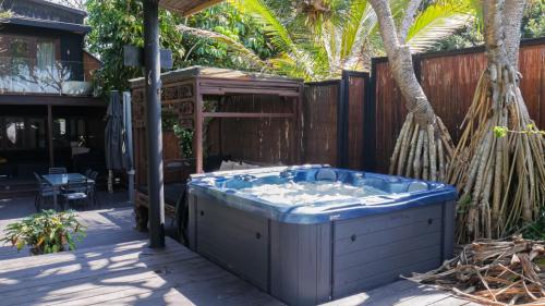 a jacuzzi tub in a backyard with a fence at Shambhala @ Byron in Byron Bay