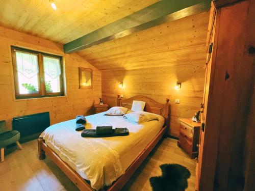 une chambre avec un lit dans une cabane en bois dans l'établissement Chalet Chez Gaby 2 - Vue imprenable au calme - Proche du centre, à Morzine