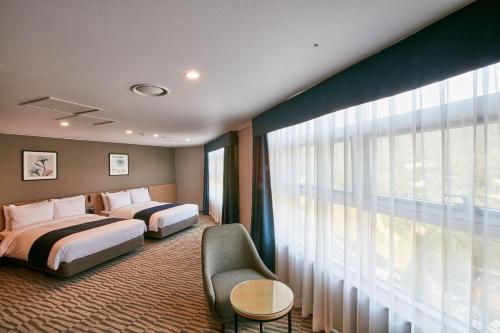 a hotel room with two beds and a window at Island Castle Hotel & Waterpark in Uijeongbu