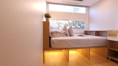 a bed in a room with a window at OYO Hostel Myeongdong 6 in Seoul