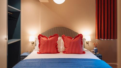 a bedroom with a bed with red and white pillows at The Trade Boutique Hotel in Cape Town