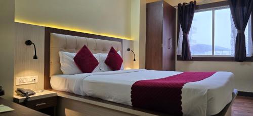 a hotel room with a large bed with red pillows at Mount Bashera Boutique Hotel in Kurseong