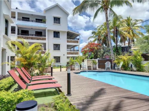 un resort con piscina e palme di Sweet Beach Apt-Pool, Terrace, Ground Floor, few steps from beach! a Flic-en-Flac