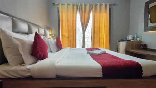 a bedroom with a large bed with red and white pillows at Mount Bashera Boutique Hotel in Kurseong
