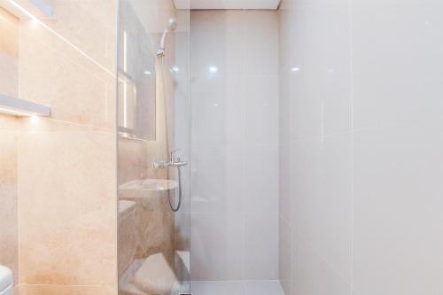 a bathroom with a shower with a glass door at Homey and Nice Studio at Transpark Bintaro Apartment By Travelio in Tangerang