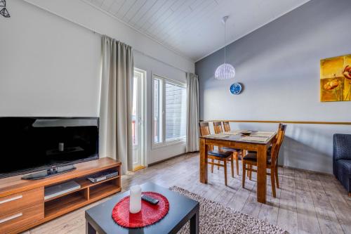 a living room with a dining room table and a tv at Holiday Apartment Skivillas 26 B 9 in Ukkohalla