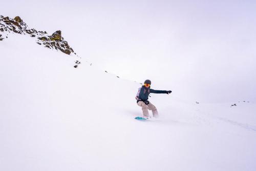 a man is skiing down a snow covered slope at SOLEA DOLOMITI Boutique Hotel in Fai della Paganella