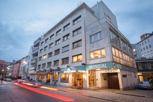 a building on a city street with cars driving past it at Centro Hotel Mondial München City, Trademark Collection by Wyndham in Munich