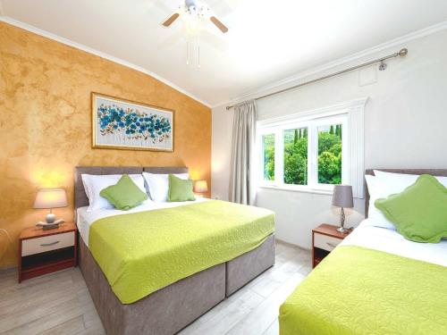 a bedroom with two beds and two windows at Villa Dubelj Dubrovnik - One-Bedroom Apartment - 1 in Komolac