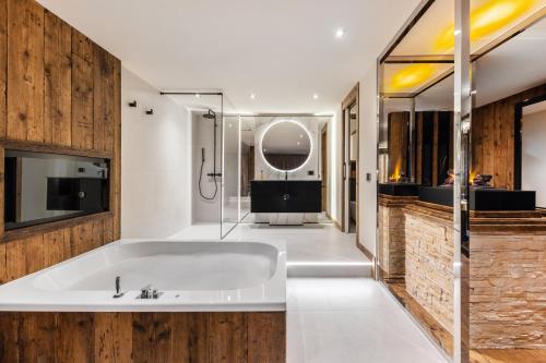 a bathroom with a white tub and a sink at SOLEA DOLOMITI Boutique Hotel in Fai della Paganella
