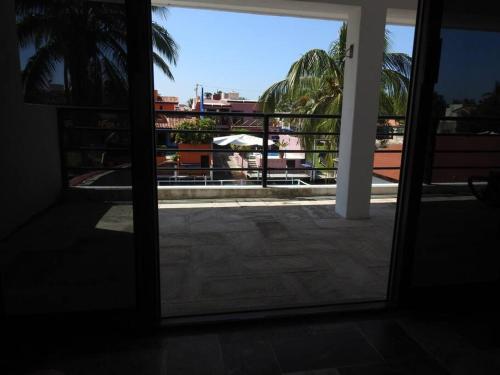 an open door to a balcony with a view of a building at Casa en el canal barra de navidad con 5 recamaras in Barra de Navidad