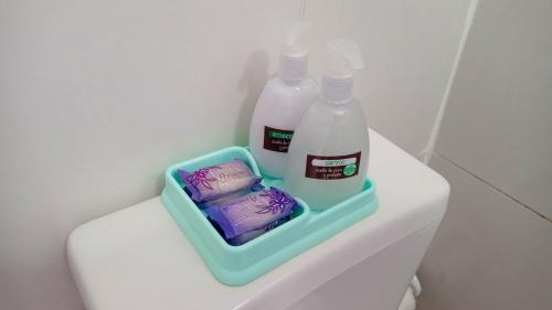 two bottles of milk and a container of soap on a toilet at Departamento - M I N I D O in Resistencia