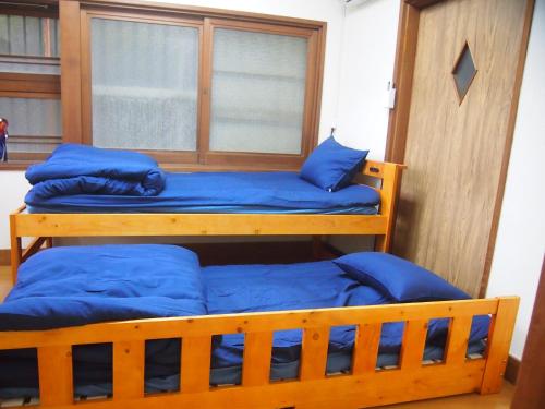 two bunk beds in a room with blue pillows at ゲストハウス柚 in Shingu