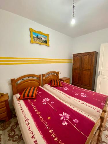 a bedroom with a large bed with a red blanket at City center apartment Kélibia in Kelibia