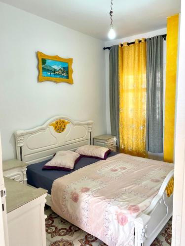a bedroom with a white bed and a window at City center apartment Kélibia in Kelibia