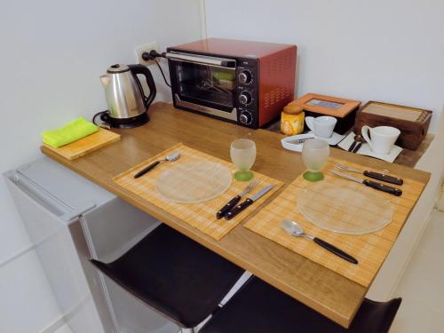 a wooden table with a toaster oven and glasses on it at Departamento - M I N I D O in Resistencia