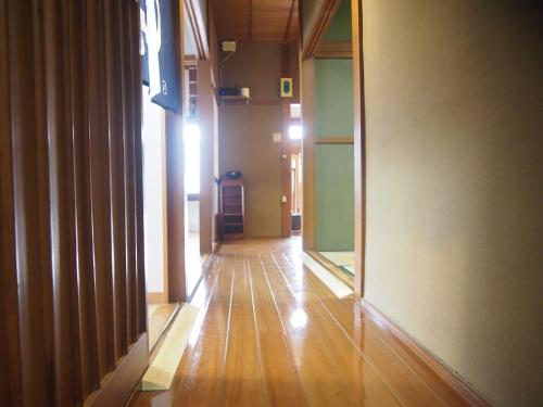 an empty hallway with wood floors and glass walls at ゲストハウス柚 in Shingu