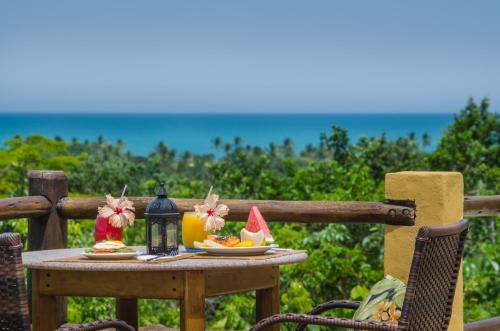 ein Tisch mit einem Obstteller und einer Kerze in der Unterkunft Pousada Mundo Verde in Trancoso
