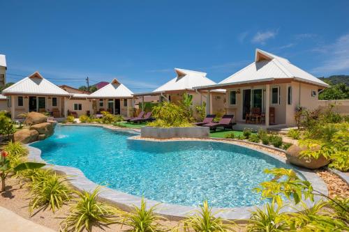 a swimming pool in front of a house at The Hidden Lagoon Resort - Exclusively for Adults in Rawai Beach