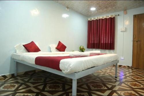 a bed with red pillows on it in a room at Dream House in Satara