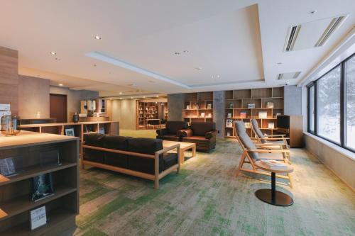 a living room with a couch and a table and chairs at Higashikawa Asahidake Onsen Hotel Bear Monte in Higashikawa