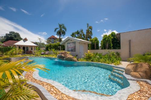 a swimming pool in a yard with rocks at The Hidden Lagoon Resort - Exclusively for Adults in Rawai Beach