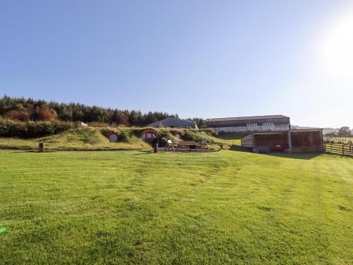 a large green field with a picnic table in it at Weirglodd in Ruthin