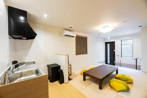 a kitchen with a sink and a table at Irodori Hotel KOU in Fukuoka