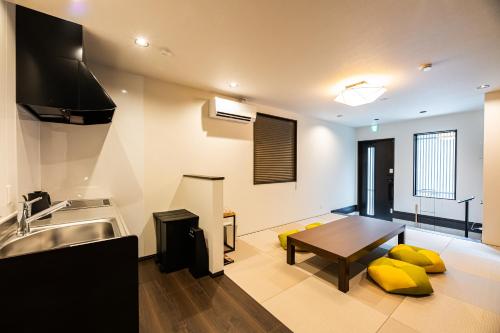 a kitchen with a table and yellow pillows on the floor at Irodori Hotel SUI in Fukuoka