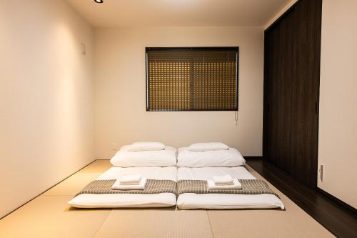 two beds in a bedroom with a window at Irodori Hotel SUI in Fukuoka