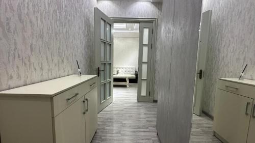 een keuken met witte kasten en een open deur bij Parkent luxe 261 in Tasjkent
