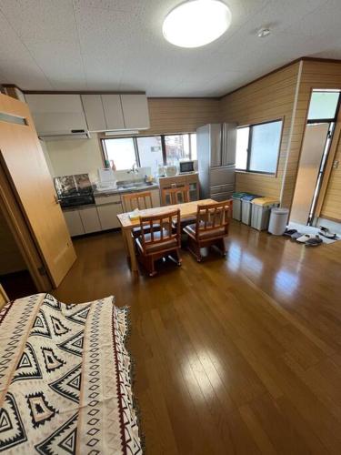 a living room with a table and chairs and a kitchen at 一棟貸切ゲストハウス in Enoura