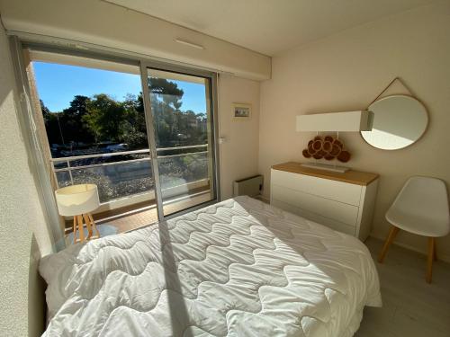 a bedroom with a bed and a large window at C219 -2 pieces avec parking proche plage in Arcachon
