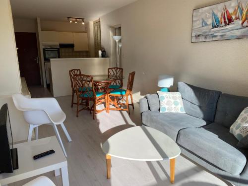 un salon avec un canapé, une table et des chaises dans l'établissement C219 -2 pieces avec parking proche plage, à Arcachon