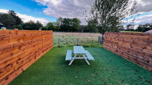 un banc bleu assis sur l'herbe à côté d'une clôture dans l'établissement Studio La chapelle, à La Roche-sur-Yon