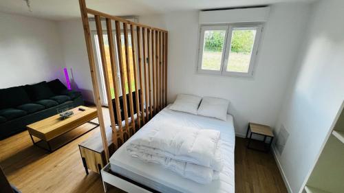 une petite pièce avec un lit et un canapé dans l'établissement Studio La chapelle, à La Roche-sur-Yon