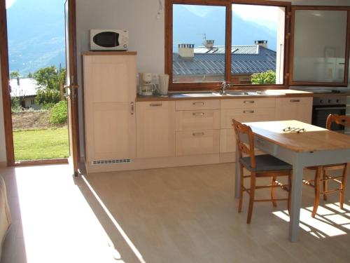 une cuisine avec une table et des chaises et une fenêtre dans l'établissement Appartement Guillestre, à Guillestre