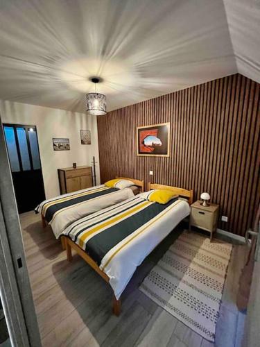 une chambre avec deux lits et un lustre dans l'établissement Logement à la Cavalerie de Montchaton, à Montchaton