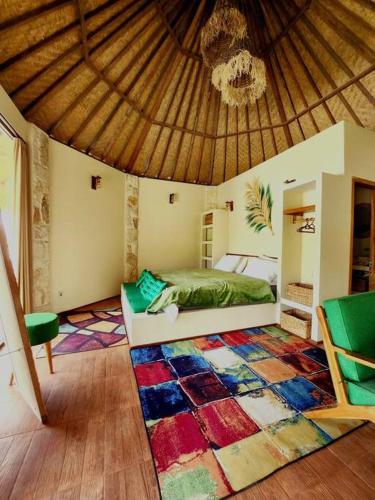 a bedroom with a bed and a large rug at Jungle Circle Uluwatu in Uluwatu