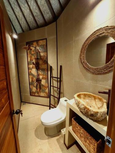 a bathroom with a toilet and a sink at Jungle Circle Uluwatu in Uluwatu