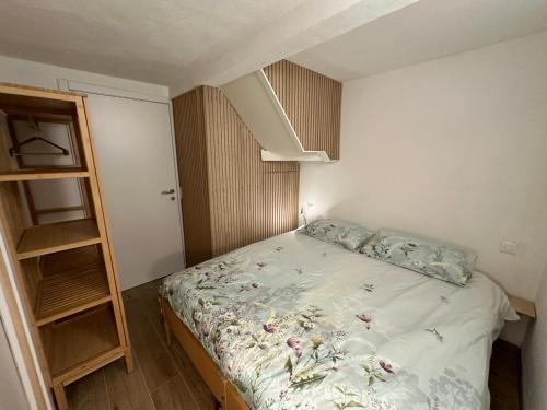a small bedroom with a bed and a book shelf at Casa sul ruscello - piano terra Casa Gauguin in Arcegno