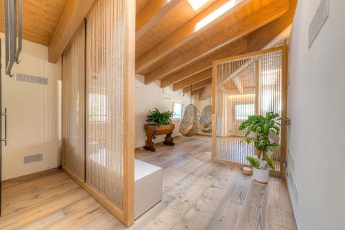 a large room with wooden ceilings and a hallway with plants at Wine Hotel Ristorante San Carlo - Boutique Hotel & SPA in Chiuro