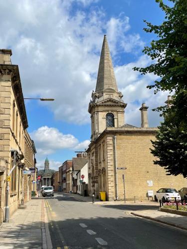 an old building with a clock tower on a street at Luxurious two-bedroom apartment in the centre of Peterborough in Peterborough