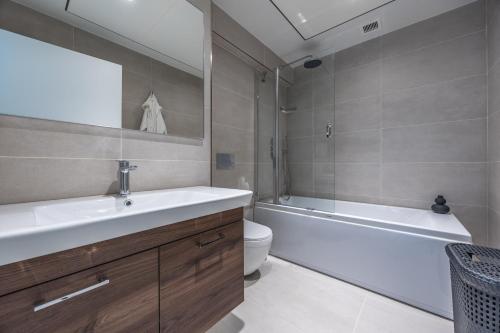 a bathroom with a sink and a tub and a toilet at Exquisite Residence in Mercury Towers in St. Julianʼs