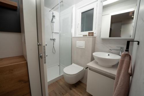 a white bathroom with a toilet and a sink at Mobile Home Gardelin in Drage