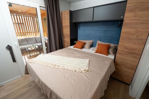 a bedroom with a large bed with orange pillows at Mobile Home Gardelin in Drage