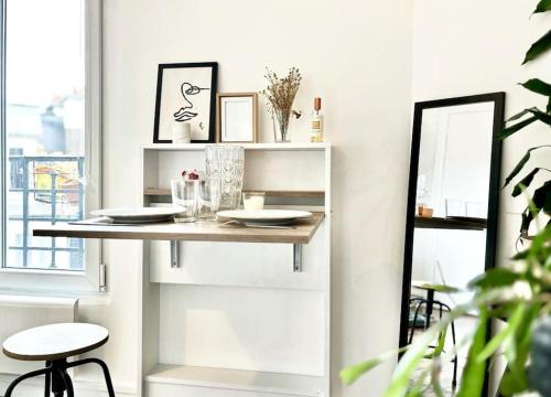 - une table dans le salon avec un miroir dans l'établissement Charmant Studio Montmartre dernier étage calme, à Paris