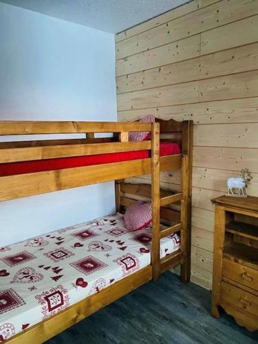 une chambre avec deux lits superposés et une table dans l'établissement L'appartement Tom d'Avoriaz, à Avoriaz