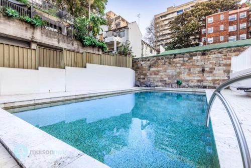 a swimming pool with blue water in a building at Harborside Studio Apt Walk to Shops Eateries in Sydney